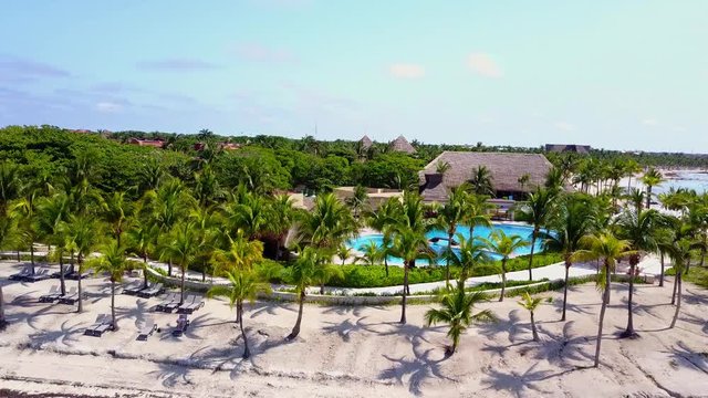 Aerial drone shot. Aerial view from above, birde eye view at an luxury resort hotel beach of a tropical coast. Turquoise water of the Caribbean Sea. Riviera Maya Mexico.