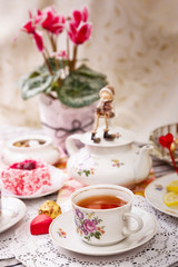 Obraz na płótnie Canvas Porcelain cup of tea with lemon and sweets