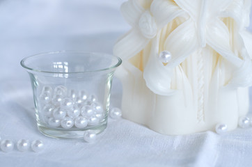 candle, white beads and glass bowl