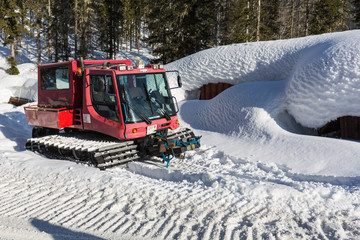 Red ratrak snowcat in winter mountains A red snow tucker covered with snow in Krkonose mountain. Red over-snow vehicle,