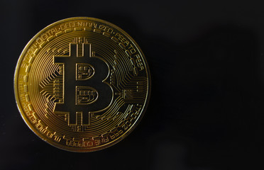 Gold souvenir coin Bitcoin on a black background.