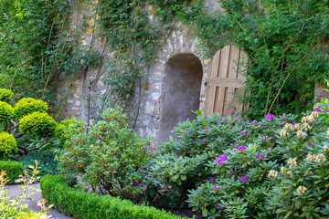 Hidden door in a stony wall in the garden of a old castle 