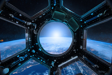 View from a porthole of space station on the Earth background. Elements of this image furnished by...