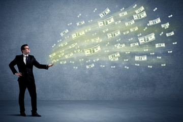 Caucasian male in business suit holding money,which flies through his hands