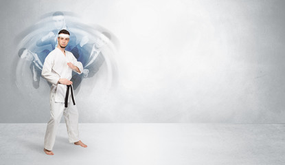 Young businessman in suit fighting with empty wall background
