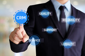 Businessman hand touch CRM, Customer Relationship Management, icon over blur background, success in business concept