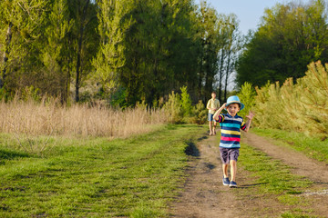happy caucasian child boy running on meadow grass, summer in nature park