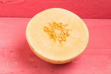 melon (sunlady) slice. half. on wood pink