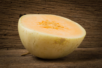 melon (sunlady) slice. half. on old wood. morning