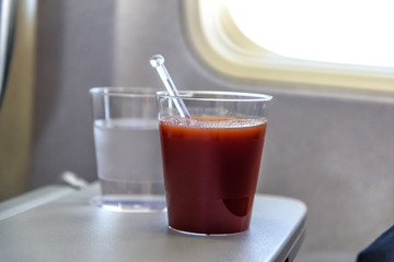 Glas mit Tomatensaft an Bord eines Flugzeugs