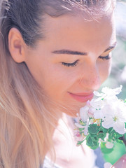 Naklejka premium Portrait of the young girl at the white spring flowers blossom