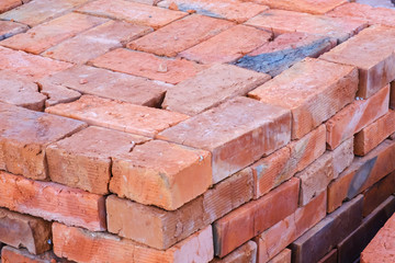 Building materials, red brick on pallet, a pile of bricks, a background of bricks close-up.