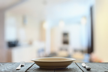 empty plate with fork and knife on wooden table