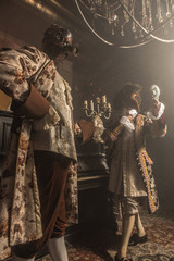 Actors in steam punk masks and antique costumes indoor.