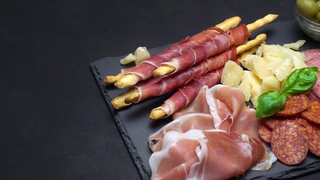 Video of italian meat plate - sliced prosciutto, sausage, grissini and parmesan