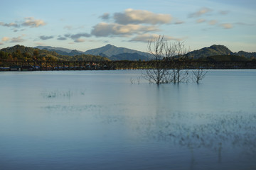 panorama view of Uttamanusorn Bridge or Mon Bridge with river and blue sky in Sangkhlaburi district,Kanchanaburi province,Thailand. Thailand’s longest wooden bridge.