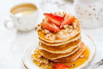 Pancakes with honey and strawberries, close up.