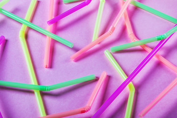 different color cocktail tubes on pink background
