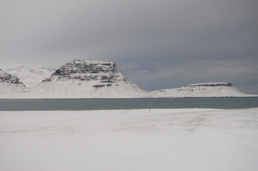 Paysage d'Islande en hiver: une montagne sous la neige au bord de la mer