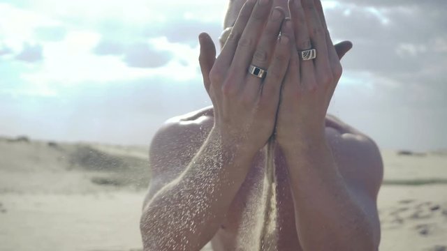 Man pours sand through his fingers