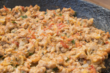 Appetizing fried minced meat with vegetables and greens in rustic old frying pan close-up