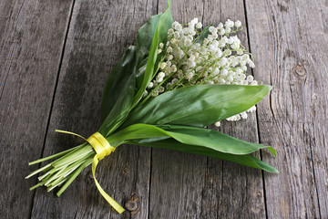 Bouquet of lily of the valley on wooden background