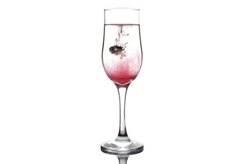 A drop of red and black liquid was just poured into a clear wineglass