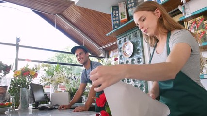 Young man and woman working at cashier counter of nursery
