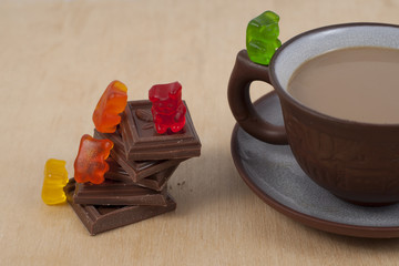 Chocolate and cup of coffee espresso on wood background