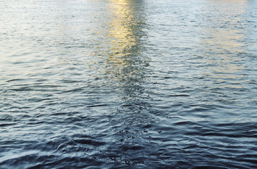 Water surface with ripples and sunlight reflections