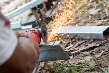 Selective focus at Steel cutter. Man use electric Steel cutter and clamp metal in factory