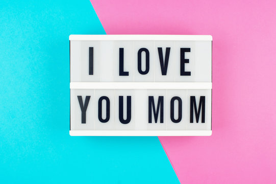 I love you Mom - text on a display lightbox on blue and pink bright background.