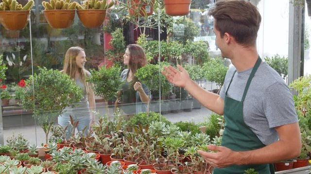 Young man in store waving at customers to come inside