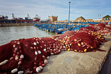 Fishing boats, gear and catch on background of Castelo Real of Mogador.