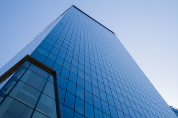 Skyscraper seen upwards, with blue sky giving windows blue color