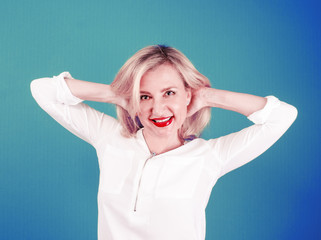 Happy mature blond woman relaxing stretching her back with her hands behind her head and looking in the camera with a smile