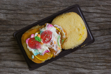 Cake defrmed ugly on wooden table.