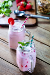 two cups of fruit strawberry yogurt on wooden background