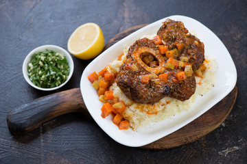 Osso buco made of cross cut veal shank served on a bed of mashed potato, horizontal shot