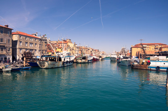 Fishing boats moored in a canal in Chioggia, Italy.