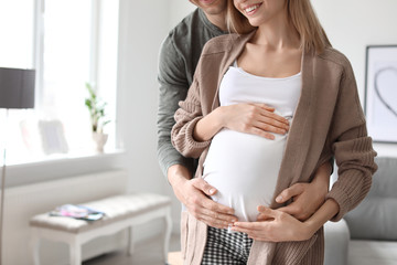 Young pregnant woman with her husband at home