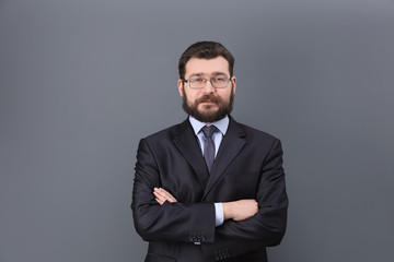 Portrait of confident mature man in elegant suit on color background