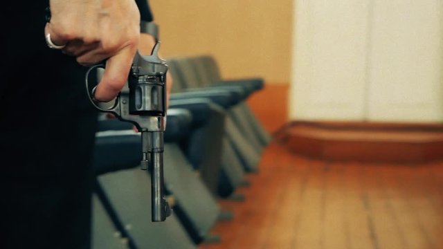 Man shoots a revolver. Soldier shoots a pistol. black gun, raise the cock,