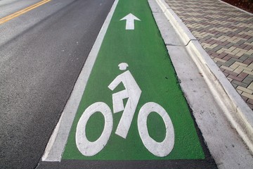 Green Bicycle Lane with Arrow Pointing Up Ahead Alongside Road with Double Yellow Lines to the Left...