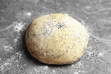 Raw dough with poppy seeds on table