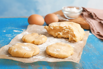 Pieces of fresh raw dough on wooden table