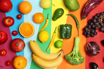 Rainbow composition with fresh vegetables and fruits on color background, flat lay