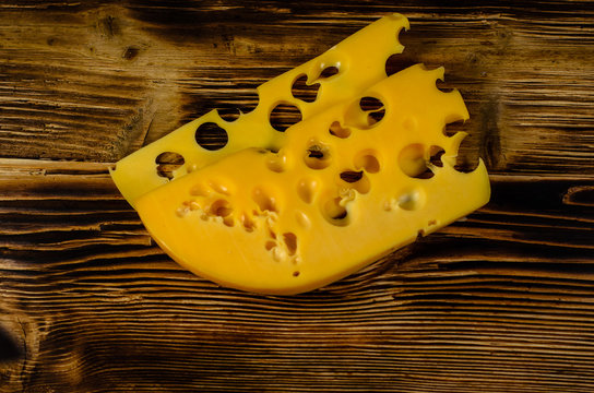 Sliced cheese on wooden table. Top view