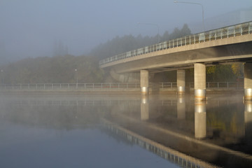 Bridge over misty and calm lake 