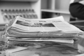 Pile of newspapers on the newspaper stand, close up